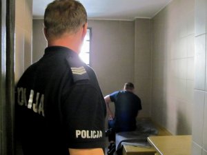 Policjant i zatrzymany mężczyzna w celi