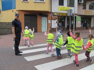 Policjant z przedszkolakami na przejściu dla pieszych