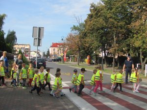 Policjant z przedszkolakami na przejściu dla pieszych