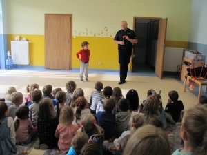 Policjant uczy dzieci w przedszkolu zasad ruchu drogowego