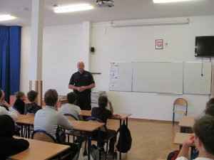 Policjant przeprowadza zajęcia z uczniami w sali