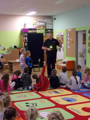 Policjant uczy dzieci w przedszkolu zasad bezpieczeństwa