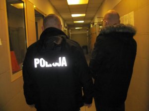 Policjant z zatrzymanym mężczyzną w pomieszczeniu dla osób zatrzymanych