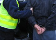 Policjant trzyma zatrzymanego mężczyznę