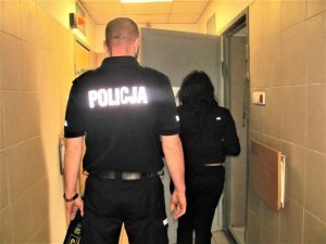 Policjant z zatrzymaną kobietą przed celą