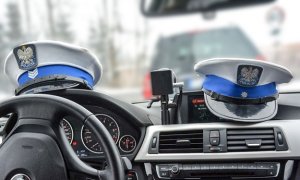 Wnętrze radiowozu z czapkami policjantów ruchu drogowego
