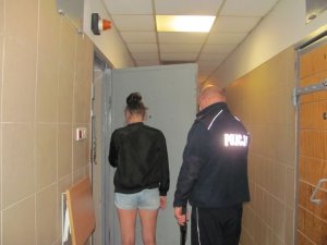 Policjant z zatrzymaną kobietą przed celą