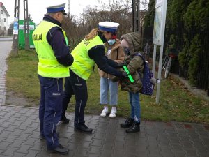 Policjanci wręczają opaskę dzieciom