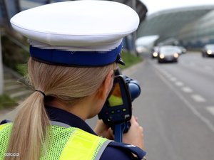 Policjantka z miernikiem prędkości na drodze