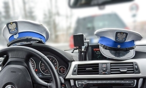 wnętrze radiowozu z czapkami policjantów drogówki