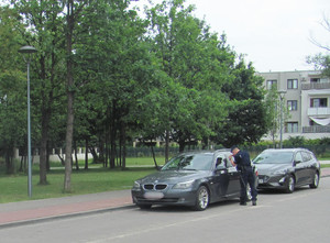 Policjant sprawdza samochód na parkingu