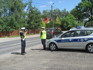 2 Policjanci przy radiowozie podczas działań na drodze