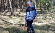 Mężczyzna w lesie niosący koszyk