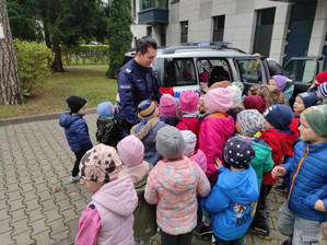 Policjant z grupą dzieci przy radiowozie