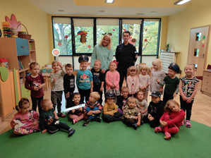 Policjant z nauczycielką i grupą dzieci w przedszkolu