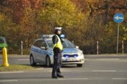 Policjant i radiowóz na drodze w jesiennej aurze