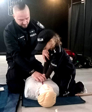 Policjant uczy dziecko udzielania pomocy