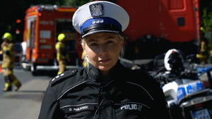Policjantka WRD, a w tle strażacy z wozem
