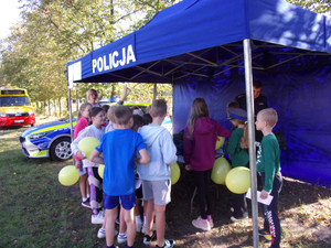 Policjant przy stanowisku z grupą dzieci na pikniku