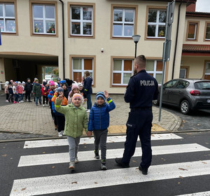 Policjant i grupa dzieci na przejściu dla pieszych