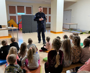 Policjant z grupą dzieci w sali przedszkola