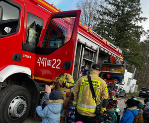 Wóz strażacki i grupa dzieci przy nim