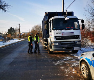 Dwóch policjantów przy pojeździe specjalnym na drodze