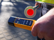 Ręka policjanta z tarczą i urządzeniem do kontroli trzeźwości