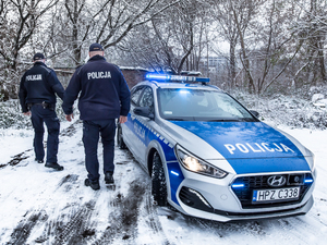 Policjanci przy radiowozie  w zimowych warunkach