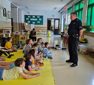 policjant z grupą dzieci w sali szkoły podczas zajęć