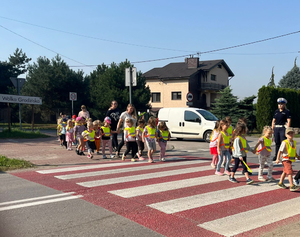 Policjantka z grupa dzieci na przejściu dla pieszych