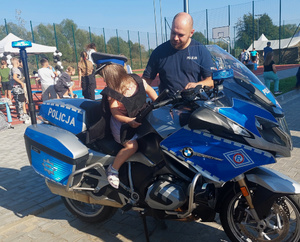 dziecko na motocyklu, obok policjant