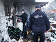 policjanci wchodzą do drewnianego domu zimą