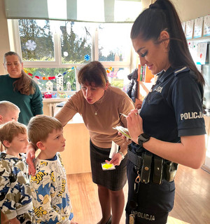 Policjantka z grupą uczniów w sali