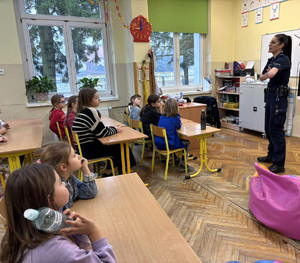 Policjantka z grupa uczniów w sali