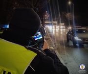 policjant z miernikiem prędkości na drodze