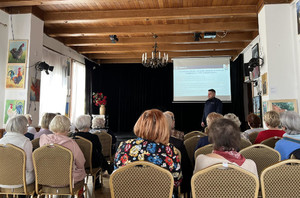 Policjant podczas spotkania z seniorami w sali Domu Kultury