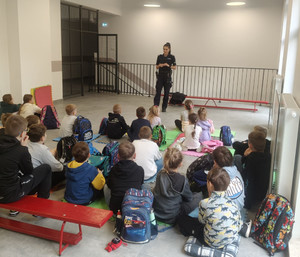 Policjantka z grupą uczniów w sali