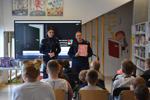 Policjantki z grupą uczniów podczas spotkania w bibliotece