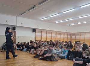 Policjantka z grupą uczniów w sali