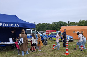 Policjant pokazuje działanie alkogogli uczestnikom pikniku