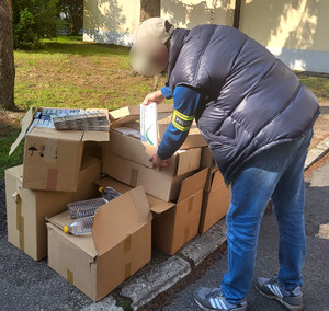 Policjant przy pudełkach z zabezpieczonym towarem