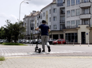 Osoba na przejściu dla pieszych prowadzi hulajnogę