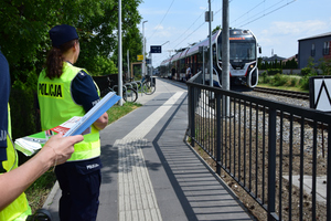 policjantki stoją z ulotkami i odbaskami na peronie