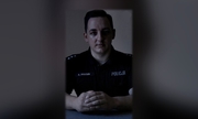 policjant siedzi przed kamerą