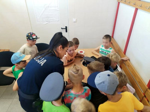 policjantka wykonuje odbitki linii papilarnych uczestnikom spotkania