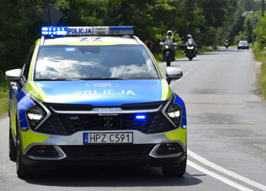 radiowóz i motory na trasie wyścigu