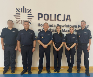 Awansowani policjanci z komendantem i naczelnikiem w sali odpraw