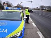 policjant przy radiowozie prowadzi kontrole prędkości