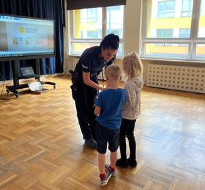 Policjantka z dziećmi na sali podczas spotkania profilaktycznego